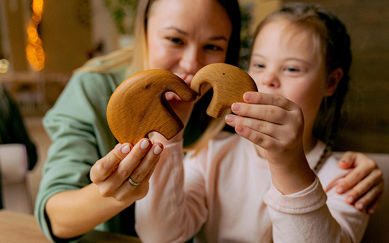 Frau und Kind mit Holzelefanten