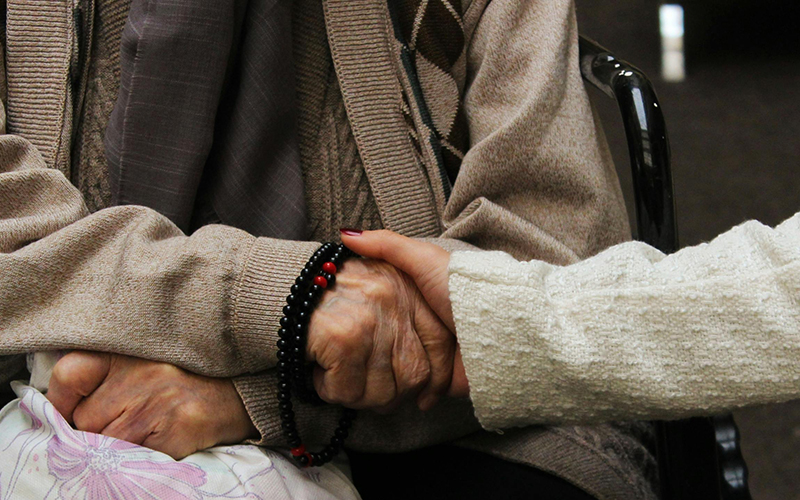 Frau hält älteren Dame die Hand