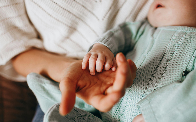 Frau hält Hand von Baby