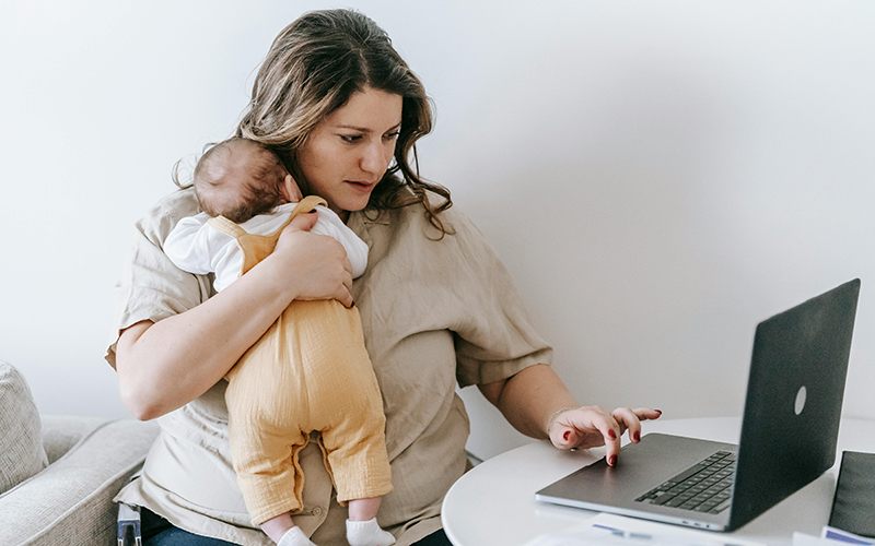 Frau mit Baby am Laptop